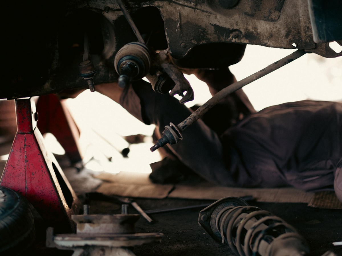 A vehicle up on the hoist being worked on from underneath