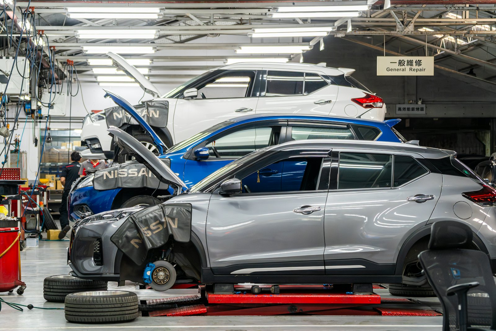 A busy general-repair workshop with several vehicles being worked on
